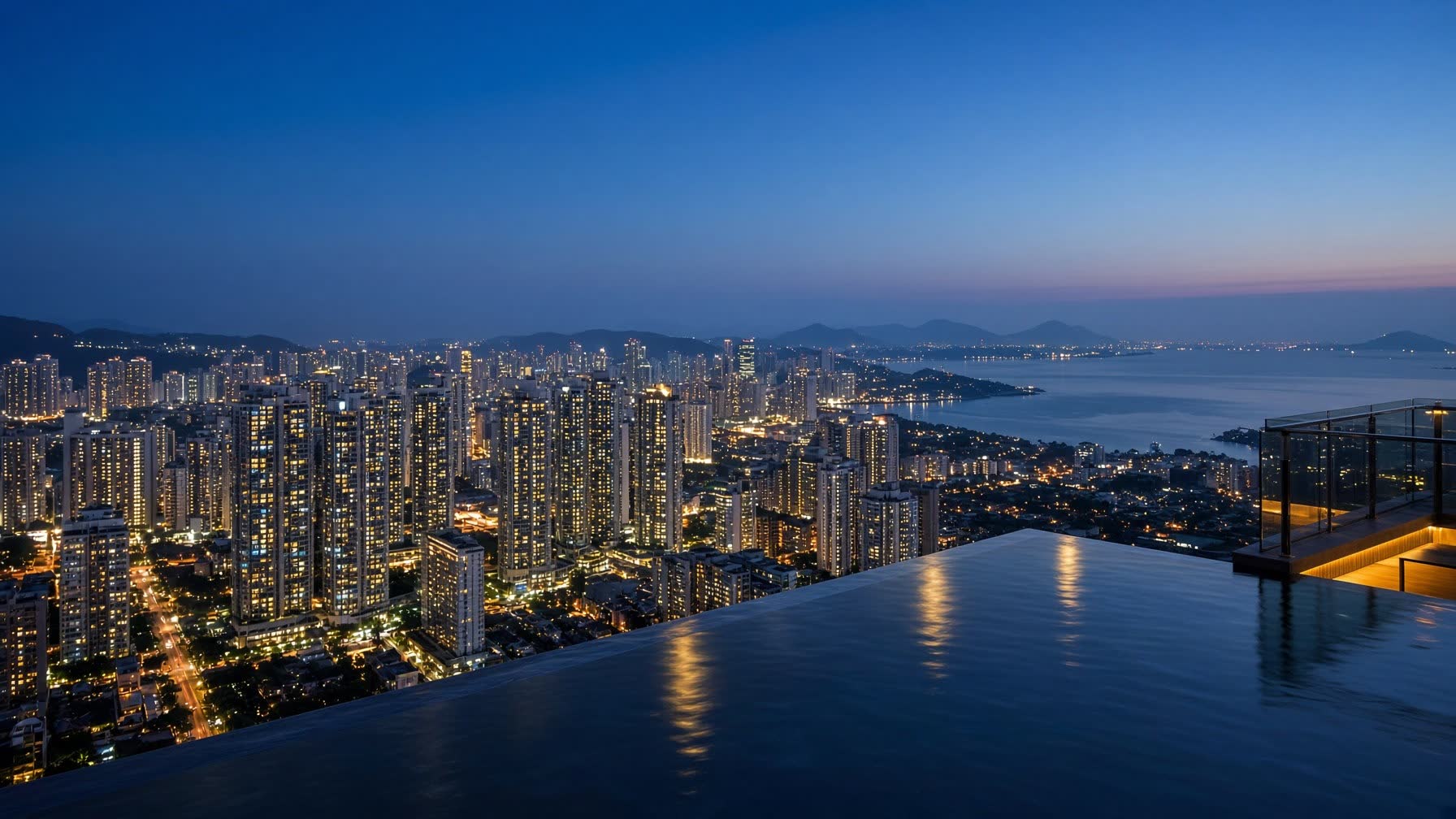 Mumbai at blue hour from a private penthouse terrace, the city glittering beyond a still infinity pool.