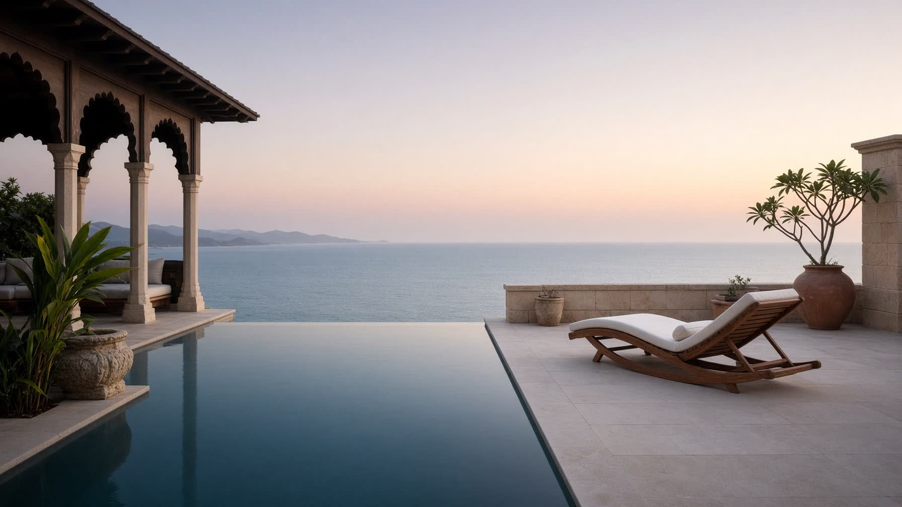 A still infinity pool on a sea-facing terrace at first light, the horizon a quiet plane of water.